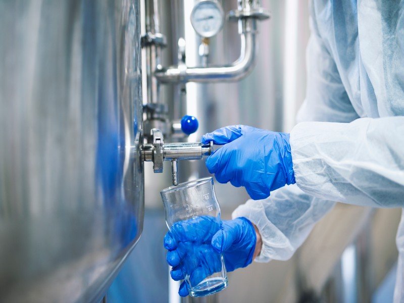 close-up-view-hands-protective-gloves-opening-tap-valve-filling-glass-with-samples-from-industrial-machine-reservoir (3)